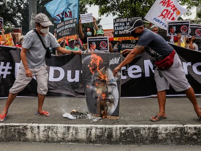 Activistas filipinos queman un cartel con la imagen de los candidatos electorales Sara Duterte y Ferdinand Marcos Jr durante una protesta