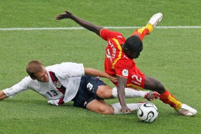 El estadounidense Jimmy Conrad (dcha.) lucha un balón con el ghanés Alex Tachie-Mensah.