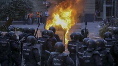 Antidisturbios de la Policia Nacional delante de un gran fuego en Via Laietana, en Barcelona.