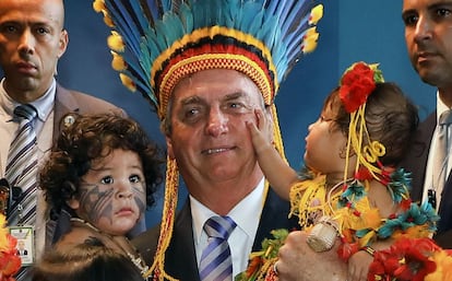 Bolsonaro con dos niños tras la ceremonia en la que ha recibido la medalla al mérito indígena, este viernes en Brasilia, en una foto difundida por Presidencia.