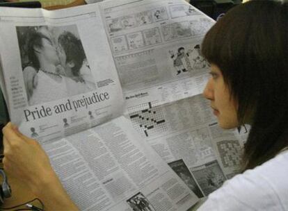 Una chica lee en la edición de hoy de 'China Daily' el reportaje sobre los homosexuales.