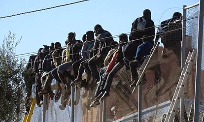 Un grupo de inmigrantes subsaharianos se queda atrapado en la valla fronteriza de Melilla tras intentar superarla en 2014.