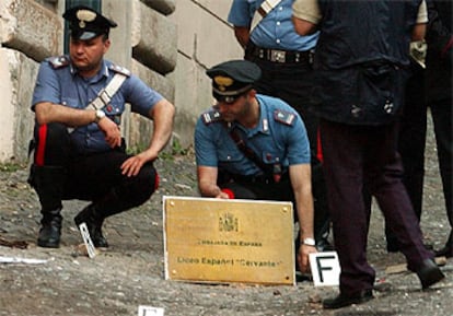 Varios carabineros italianos inspeccionan el lugar donde estalló la bomba contra el liceo español en Roma.