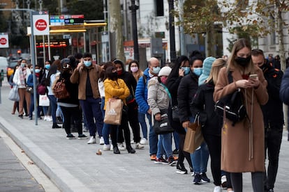 Shoppers wait in line outside a clothes store in barcelona on Friday