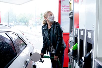 Una mujer reposta combustible en su coche, en Madrid.