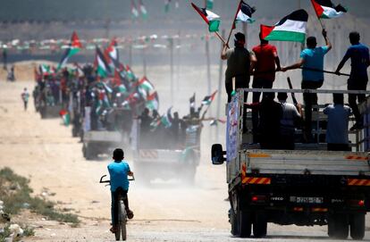Manifestantes palestinos se desplazan con banderas nacionales cerca de la frontera con Israel, al este de Gaza.