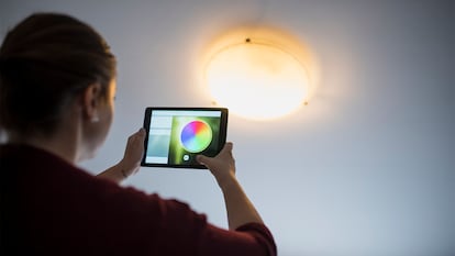 Una chica cambiando el color de su lámpara.