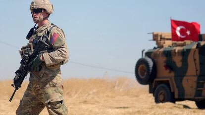 Soldado norte-americano caminha próximo de um veículo militar turco durante patrulha conjunta ao norte da região síria de Tel Abiad, em setembro