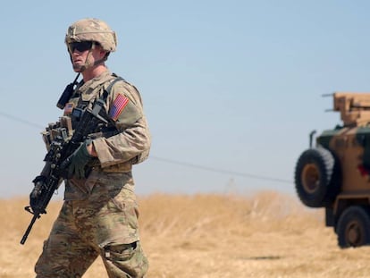 Soldado norte-americano caminha próximo de um veículo militar turco durante patrulha conjunta ao norte da região síria de Tel Abiad, em setembro