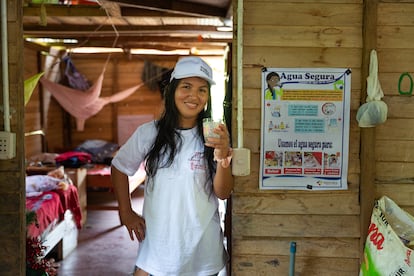 Raquel Roncal posa en su casa junto al cartel que tienen todas las viviendas de las familias que participan en el proyecto y que recuerda hervir el agua unos cinco minutos antes de su consumo.