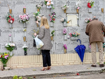 Dos personas en un cementerio madrileño.