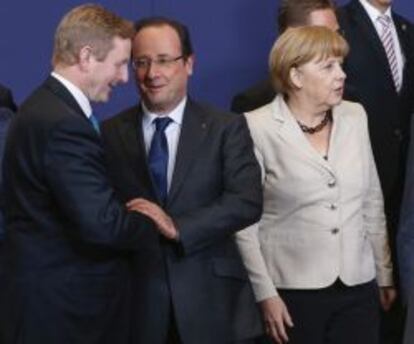 El primer ministro irland&eacute;s, Enda Kenny habla con el presidente franc&eacute;s, Francois Hollande, junto a la canciller alemana, Angela Merkel, mientras posan para la tradicional foto de grupo durante la cumbre europea en Bruselas ayer jueves 27 de junio de 2013. 