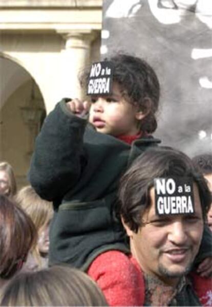 Un niña sobre los hombros de su padre participa en la manifestación que se celebró en la capital oscense contra la guerra de Irak, que congregó a unas cinco mil personas según la Coordinadora contra las Guerras de Huesca. La policía cifró el seguimiento de la marcha en 3.500 personas.