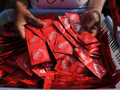 Personas cogen preservativos en Nueva Delhi (India), durante el D&iacute;a Internacional del Cond&oacute;n.
 