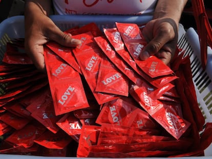 Personas cogen preservativos en Nueva Delhi (India), durante el D&iacute;a Internacional del Cond&oacute;n.
 