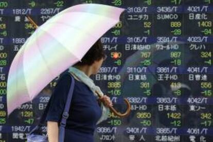 Una mujer observa la información bursátil en una pantalla informativa en Tokio (Japón).