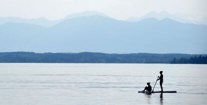 Dos jóvenes practican paddle surf en el lago Starnberger en Percha (Alemania).