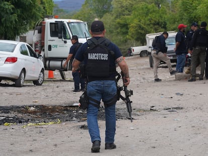 A Mexican narcotics agent investigates the scene of an armed attack in Michoacan; June 30.