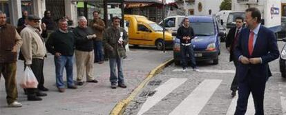 Vecinos miran sorprendidos a Rajoy al llegar a Dos Hermanas, antes de iniciar su paseo por la ciudad.