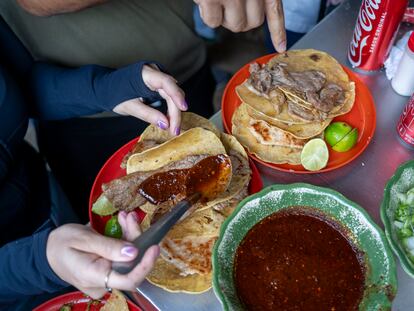 Una mujer sirve salsa a sus tacos en El Califa de León, taquería en Ciudad de México ganadora de una estrella Michelin, en mayo de 2024.