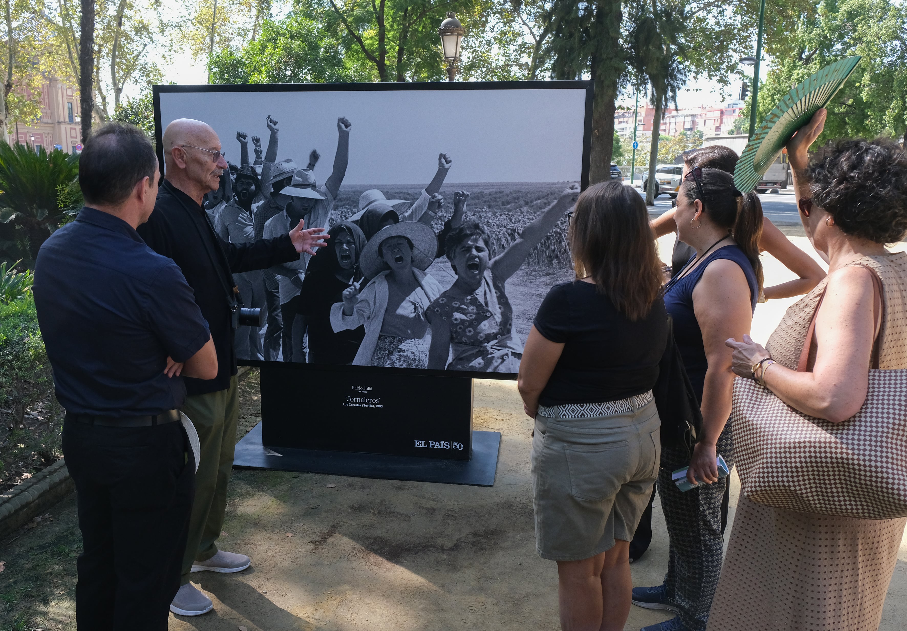 El fotoperiodista Pablo Juliá explica cómo tomó su foto de las protestas jornaleras a varios suscriptores de EL PAÍS, en la inauguración de la exposición 'Momentos', por el 50º aniversario del diario foto.ALEJANDRO RUESGA