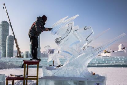 Un artista da forma a su escultura de hielo durante una competición celebrada dentro del Festival de Hielo y Nieve de Harbin.