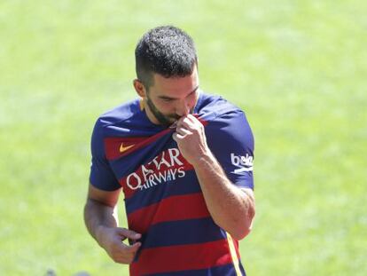 Arda Turan besa en el escudo del Barcelona en su presentaci&oacute;n.