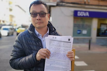 Enguan Chen muestra su hoja de reclamación ante la sucursal del BBVA en Usera.