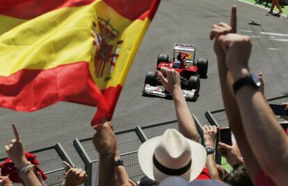 El español de Ferrari saluda al público ondeando una bandera española