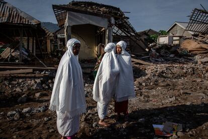 Mujeres indonesias se abrazan después de realizar el rezo del Eid al-Adha en Pemenang. Miles de residentes permanecen varados en la isla indonesia de Lombok mientras luchan por recuperarse de los terremotos anteriores.