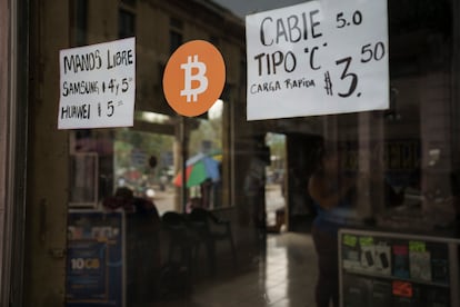 Una tienda de teléfonos celulares muestra un cartel de Bitcoin en San Salvador, El Salvador, en 2022. 