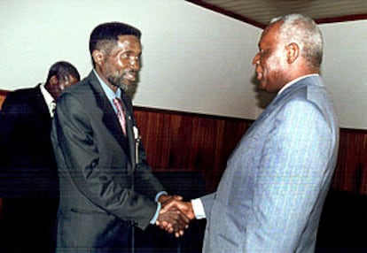 El presidente de Angola, Dos Santos (derecha), estrecha la mano del representante de UNITA, Paulo Lukamba.