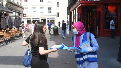 Una sanitaria ofrece un test rápido a una joven que pasea por Carnaby este lunes en Londres.