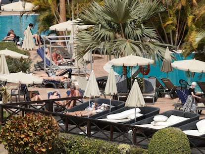 Varios turistas confinados en el hotel Costa Adeje Palace de Tenerife toman el sol con mascarillas, este miércoles.