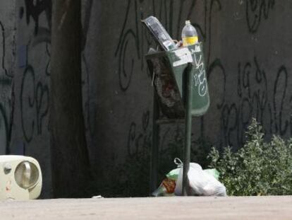 Papeleras rebosantes y desperdicios en el suelo de una calle de Madrid el pasado s&aacute;bado.