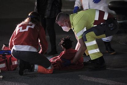 Uno de los niños atendidos por los servicios de emergencia en la noche del martes, sobre el asfalto del muelle de Arguineguín.