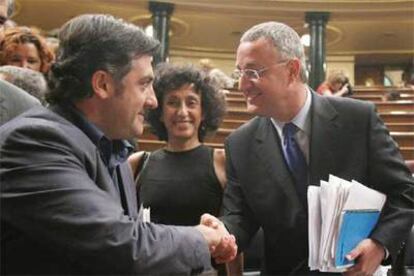 El ministro Jesús Caldera (derecha) saluda al portavoz de ERC, Joan Puigcercós, ayer en el Congreso.