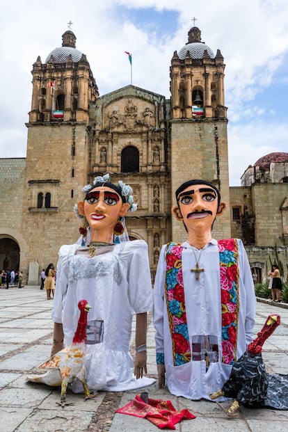 Dos monos de calenda, titéres gigantes utilizados en bodas y fiestas de Oxaca, vestidos con trajes de novios.