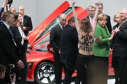 Russian President Vladimir Putin (C) is attacked by an activist of the Ukrainian women rights group 'Femen' as German Chancellor Angela Merkel (R) looks on during their visit of the industrial exhibition "Hannover Messe" April 8, 2013 in Hannover, Germany. More than 100 Russian companies are exhibiting their industrial productions.