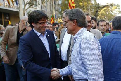 El actual presidente catalán, Carles Puigdemont,saluda al expresidente catalán, Artur Mas.