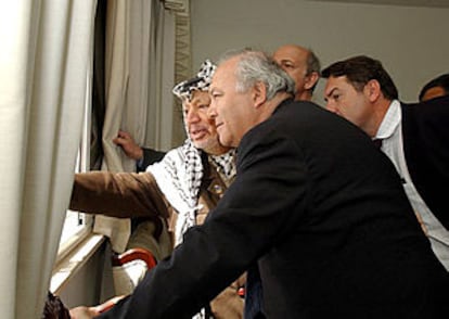 Arafat muestra al enviado especial de la UE, Miguel Ángel Moratinos, los daños del ataque a su residencia de Ramala.