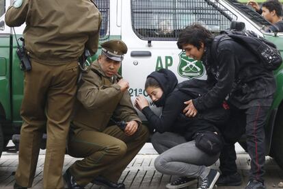 Un policía y estudiantes se refugian de un ataque con piedras. Hace un año la presidenta, Michelle Bachelet, presentó una reforma educativa para restringir los procesos de selección de las instituciones educativas que reciben apoyo público; evitar que los padres deban ayudar a pagar la educación de sus hijos en el sistema público, y buscar que nadie lucre con la educación. Sin embargo, los estudiantes siguen sin percibir grandes cambios.