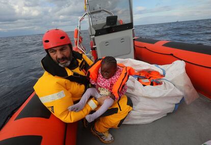 Oscar Camps, fundador de la ONG Proactiva Open Arms, sujeta a un niño dentro de una nave de rescate a unas 36 millas náuticas frente a la costa de Libia.