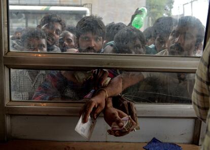 Trabajadores compran boletos de autobús en un mostrador del Centro de Recepción Turística de Jammu y Cachemira, en Srinagar (India). Este miércoles, un manifestante murió después de ser perseguido por la policía durante el toque de queda en la ciudad principal de Cachemira. Esta muerte es la primera que se ha producido desde que el Gobierno nacionalista hindú del primer ministro Narendra Modi retirara el lunes por decreto presidencial la autonomía constitucional al estado de Jammu y Cachemira.