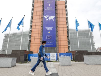 Una mujer camina frente a la sede de la Comisión Europea.