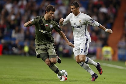 El delantero portugués del Real Madrid Cristiano Ronaldo (d) y el defensa del Legia Varsovia, Bartosz Bereszynski durante el partido de Liga de Campeones disputado en el estadio Santiago Bernabéu.
