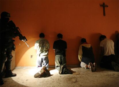 Un miembro de las fuerzas especiales mexicanas vigila a un grupo de detenidos durante un operativo contra el narcotráfico en Ciudad de México.