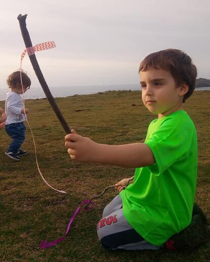 Un niño con su bordón con una cinta al viento.