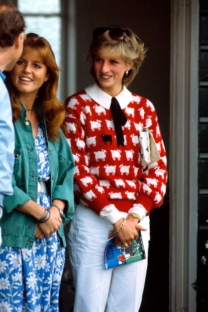 Una imagen muy ochentera de Diana (con Sarah Ferguson al lado), luciendo un jersey de ovejitas -una de ellas negra, hay que encontrarla- con camisa de cuello bebé decorada con un lacito y una cartera de mano. ¿Quién no ha llevado un look así en aquellos años?