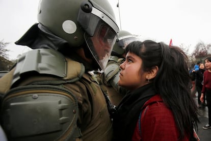 Manifestante mira a los ojos a un policía antidisturbios en Chile durante una protesta con motivo del aniversario del Golpe de Estado de 1973.